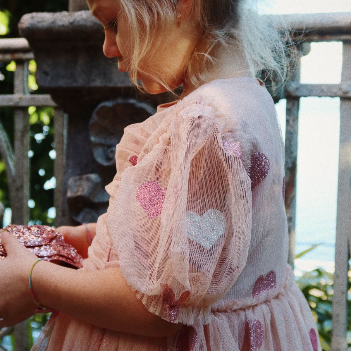 Wat een plaatje is de tullie jurk heart rose glitter van Konges Slojd! De roze tulen jurk met pofmouwen en ruffles is bezaaid met glinsterende hartjes. VanZus