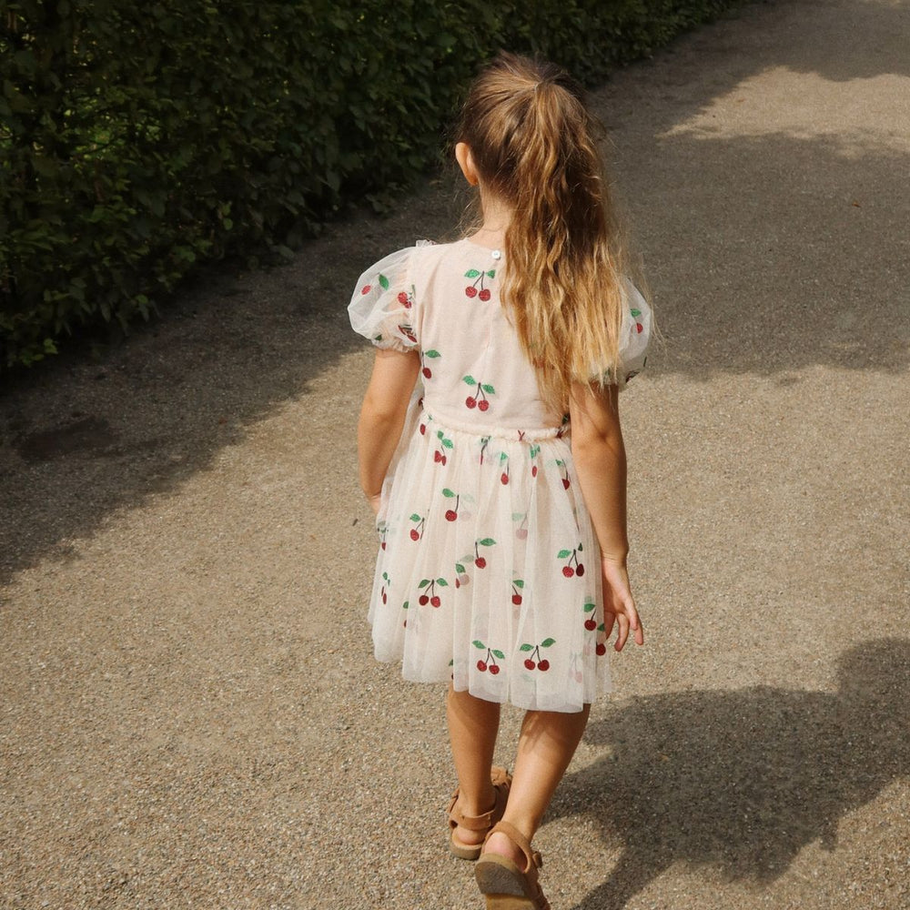 Wat een plaatje is de tullie jurk in de variant ma grande cerise glitter van Konges Slojd! De roze tulen jurk met pofmouwen en ruffles is bezaaid met glinsterende hartjes. Een geweldige jurk voor een verjaardag, bruiloft of feestje! VanZus
