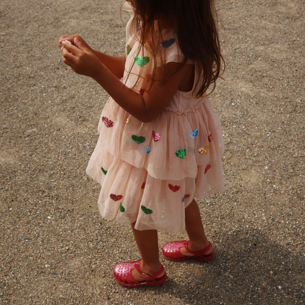 Op zoek naar een feestelijke jurk? Zoek dan niet verder want de Konges Slojd yvonne frill jurk in de variant coeur sequins is feestelijk en schattig tegelijk! Een stijlvolle keuze voor jouw kleine meid. VanZus