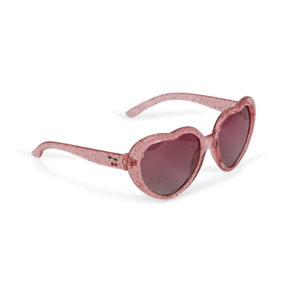De Konges Slojd zonnebril junior in de kleur heart cherry glitter is de perfecte accessoire voor zonnige dagen. Deze stijlvolle zonnebril biedt 100% UV-bescherming met gepolariseerde lenzen, waardoor de ogen van je kind veilig zijn tegen schadelijke stralen. VanZus