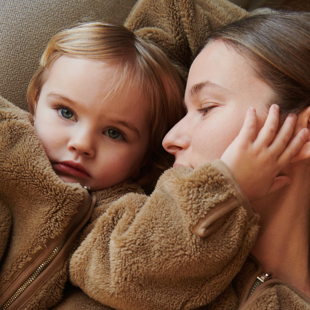 De Liewood calina teddy jas in de kleur oat is een heerlijk zacht jack dat je kindje warm houdt tijdens de koude herfst- en winterdagen. Er is ook een versie voor volwassenen dus je kunt twinnen met je mama! VanZus.