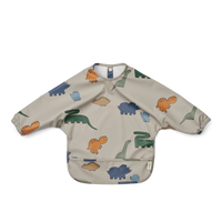 Eten en knoeien doet je kleintje in stijl met de slab merle van Liewood uit de collectie dinosaurs/mist. Het slabbetje met lange mouwen is perfect voor kinderen die leren te eten. Het gerecycelde materiaal zorgt ervoor dat je het slabbetje gelijk kan afspoelen en schoonvegen na het eten. VanZus