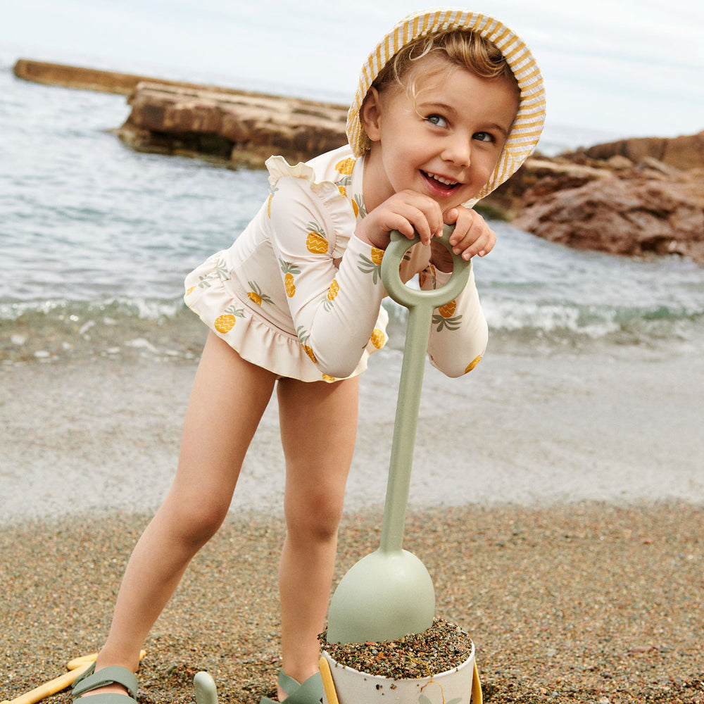 Bescherm je kindje tijdens het spetterplezier met dit leuke sille badpak van Liewood in de kleur pineapples/cloud cream! Dit superfijne zwempak ziet er niet alleen te schattig uit, maar beschermt je kindje ook tegen de schadelijke UV-straling van de zon. VanZus