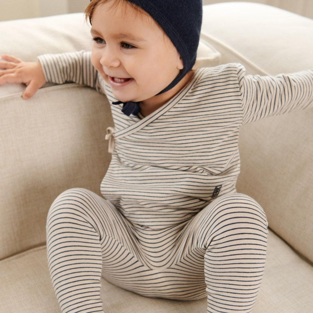 Voeg een vleugje klassiek toe aan de outfit van je kindje met het tadeo wikkelvestje in stripe sandy/classic navy van Liewood. Eenvoudig aan- en uit te trekken, gestreepte  zachte jersey stof. VanZus