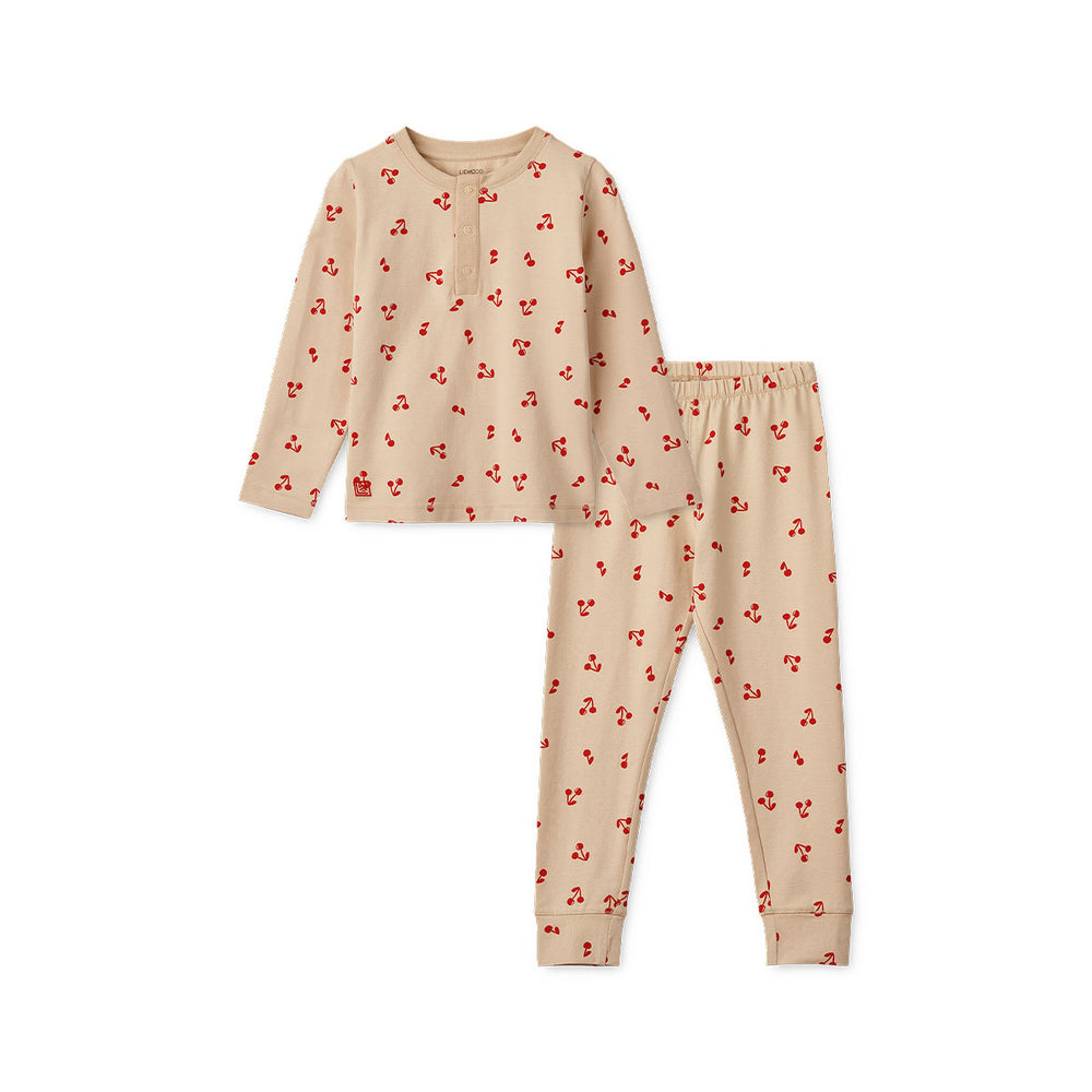 Kijk hoe leuk deze Liewood Wilhelm pyjama cherries/apple blossom is!  Deze leuke kinderpyjama is beige en heeft een print met schattige rode kersen. De stof van de pyjama is gemaakt van 95% biologisch katoen. Dat maakt het extra zacht voor de huid. VanZus