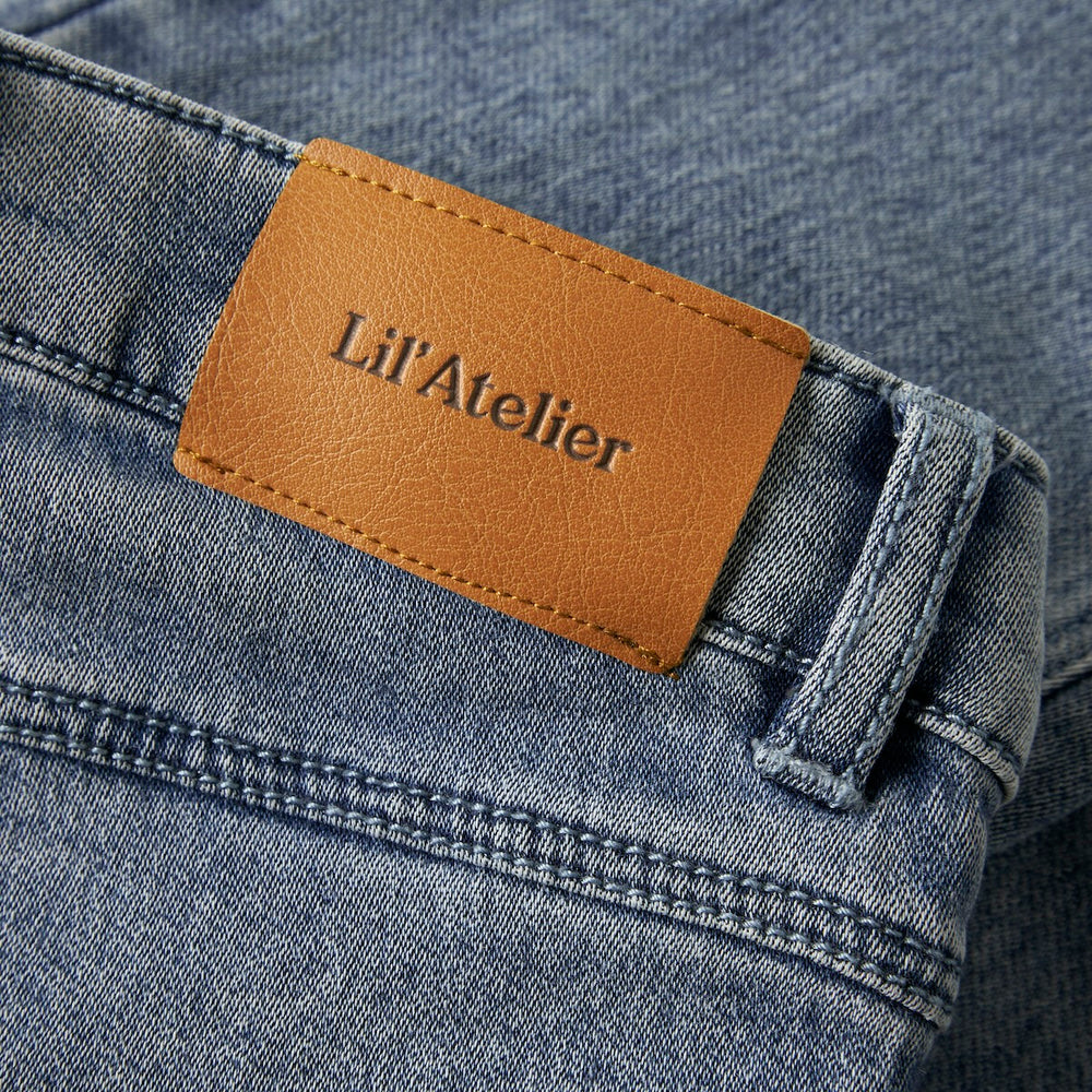 De nadie wijde denim jeans medium blue denim van Lil' Atelier is de perfecte aanvulling op de garderobe van je kleintje. Deze stijlvolle spijkerbroek is ideaal voor zowel speelse avonturen als gezellige familiebijeenkomsten. VanZus