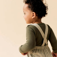 Lil' Atelier baby balou overall in moss gray. Loose fit van 100% biologisch katoen met bretels, elastische taille en geweven structuur. Comfortabel, stijlvol en duurzaam. Voor een klassieke look. VanZus