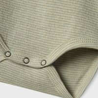 Dit schattige baby feng slim rompertje in de kleur moss gray is een ideaal basic om in huis te halen voor jouw kleine spruit. Dit mooie rompertje van hoge kwaliteit is de ultieme basic voor diverse outfits en zal jouw kleintje gegarandeerd leuk staan! VanZus