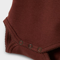 Het baby gayo koj slim rompertje in de kleur hot chocolate van het merk Lil' Atelier is een onmisbaar item voor de garderobe van je kleintje. Gemaakt van katoen en elastaan, combineert dit rompertje comfort met duurzaamheid. VanZus