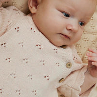Lil' Atelier baby jola knit jurk in morganite: gemaakt van biologisch en gerecycled katoen. Comfortabele regular fit met O-hals en knoopsluiting. Perfect voor elke gelegenheid. VanZus
