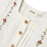 Lil' Atelier baby jolene shirt in coconut milk. Gemaakt van 100% biologisch katoen, loose fit met button down-kraag en knoopsluiting. Stijlvol met geborduurde details. Een must-have! VanZus