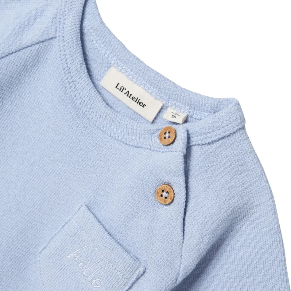 Het baby jollo sweatshirt in zen blue van Lil' Atelier is  gemaakt van 100% biologisch katoen. Comfortabel met een O-hals en knoopsluiting. Voorzak en regular fit. Combineer met bijpassend short. VanZus