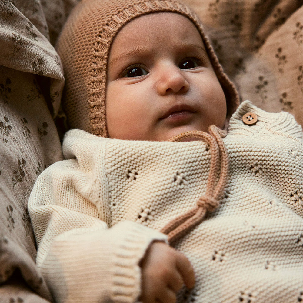 Het baby laguna wrap knit vestje in de mooie kleur turtledove van het merk Lil' Atelier is een stijlvolle en comfortabele keuze voor elk kind. Dit fijne vestje is gemaakt van 100% biologisch katoen, wat zorgt voor een zachte en huidvriendelijke ervaring. VanZus