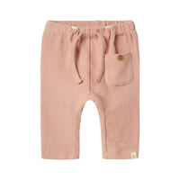 De baby luna broek in misty rose van het merk Lil' Atelier is de ideale keuze voor het creëren van stijlvolle en comfortabele outfits voor jouw kleintje. Gemaakt van een mix van biologisch katoen en elastaan, biedt deze broek zowel zachtheid als een goede pasvorm. VanZus