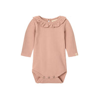 Dit comfortabele en schattige baby luna rompertje in de variant misty rose van het merk Lil' Atelier is echt de ultieme basic romper voor in de kledingkast van je kleintje! VanZus