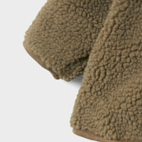 Hoe schattig is de baby nalo sherpa jas in de kleur solid overland trek van het Nederlandse merk Lil' Atelier? Het jasje is te dragen in alle seizoenen, als tussenjas, vestje of zomerjasje. En door de mooie donkergroene kleur is de jas echt een blikvanger. VanZus