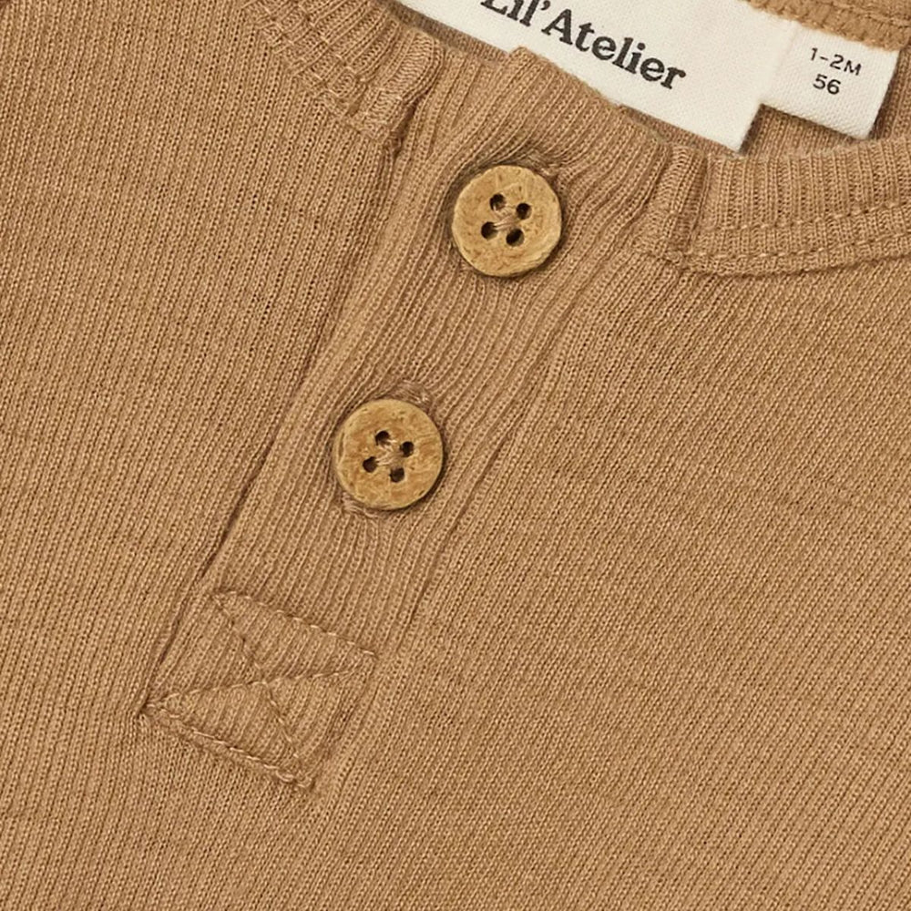 Comfortabel & stijlvol: Lil' Atelier baby noel slim wol rompertje in tigers eye. Gemaakt van 100% merinowol, O-hals met knoopdetails, lange mouwen en drukknoopsluiting. Een fijne basic! VanZus