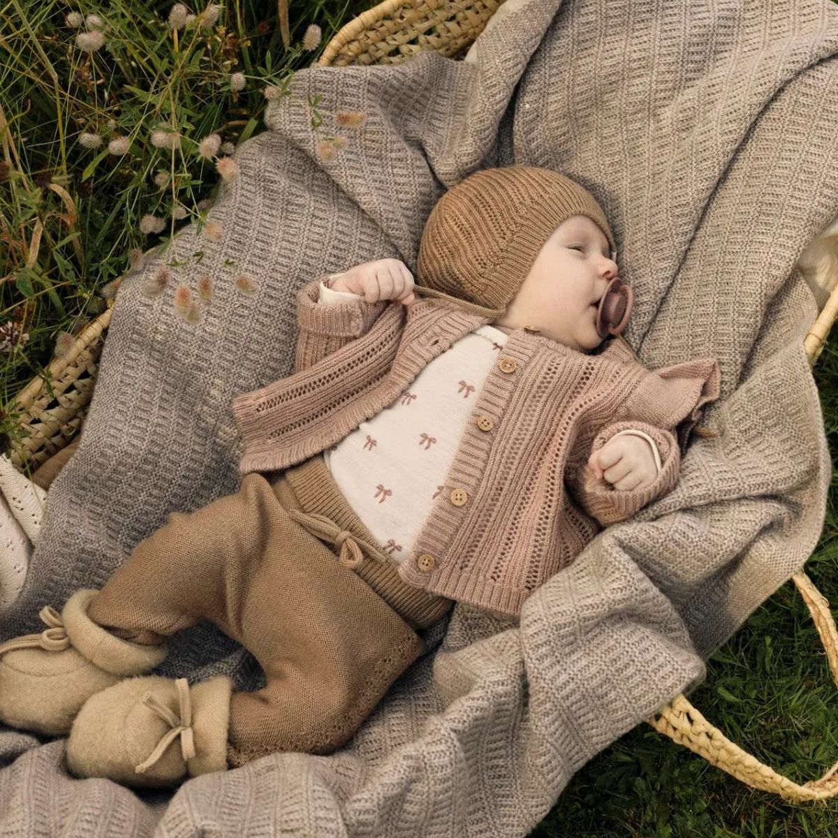 Het baby gebreid vestje in roebuck van Lil' Atelier is gemaakt van 100% RWS-gecertificeerde wol voor comfort en duurzaamheid. Met ruches, geribde zoom en knoopsluiting. Perfect voor herfst/winter. VanZus