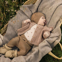Het baby gebreid vestje in roebuck van Lil' Atelier is gemaakt van 100% RWS-gecertificeerde wol voor comfort en duurzaamheid. Met ruches, geribde zoom en knoopsluiting. Perfect voor herfst/winter. VanZus