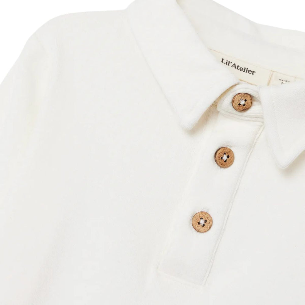 Lil' Atelier fundo slim polo in coconut milk, een stijlvolle top voor jongens. Gemaakt van biologisch katoen en TENCEL™ voor comfort en duurzaamheid. Perfect voor elke gelegenheid. VanZus