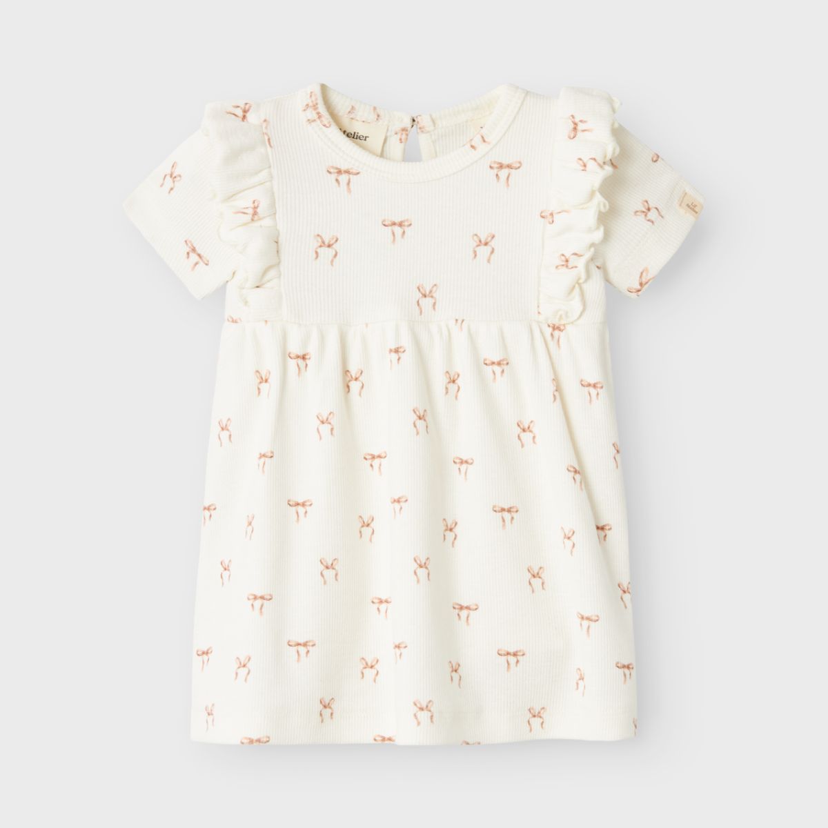 Een prachtige witte romper jurk die perfect is voor feestelijke gelegenheden, maar ook casual gedragen kan worden, dat is coconut milk romper jurk van het mooie merk Lil' Atelier. Deze mooie jurk heeft een witte kleur en een schattige print van strikjes, wat de jurk een nette uitstraling geeft. 