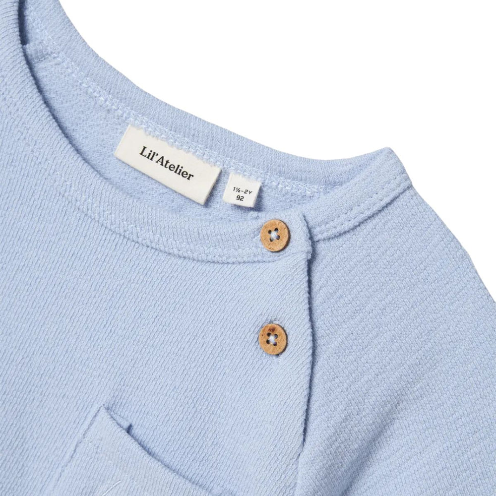 Het jollo sweatshirt in de kleur zen blue van het merk Lil' Atelier is gemaakt van 100% biologisch katoen. Regular fit met O-hals en korte mouwen, perfect voor een comfortabele en trendy look. VanZus