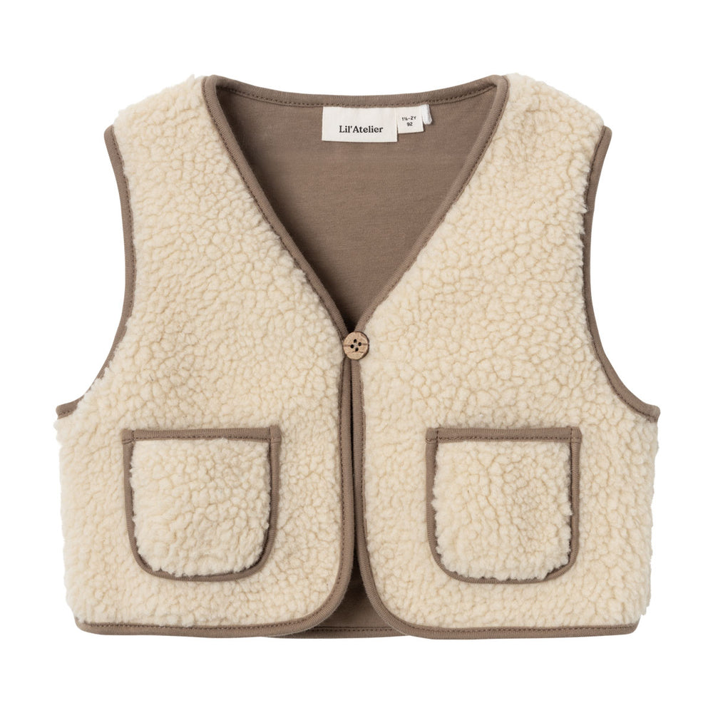 Dit schattige jono sherpa vest in de kleur birch van het merk Lil' Atelier maakt elke outfit helemaal af! Het is het perfecte winterse item voor knusse herfst- en winterlooks en biedt je kind extra warmte en comfort. VanZus