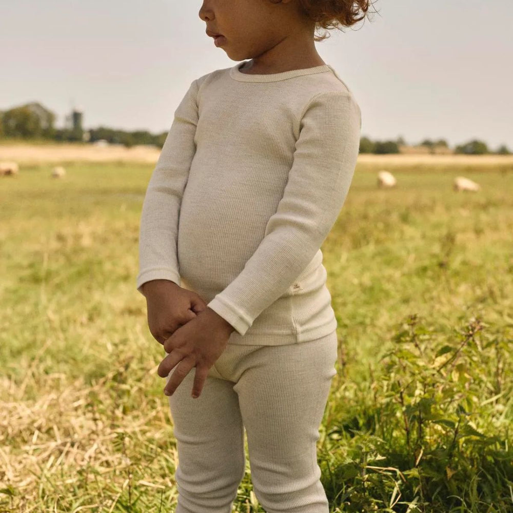 Een fijne basic: het Lil' Atelier nalu rib slim shirt in turtledove melange, gemaakt van zachte merinowol en TENCEL™. Dit unisex shirt biedt comfort en stijl voor je kind, perfect voor de herfst en winter! VanZus
