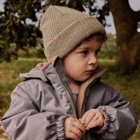 De Lil' Atelier nanson knit muts in de kleur overland trek is de perfecte finishing touch voor de winteroutfit van je kleintje. De muts is gemaakt van een zachte gebreide stof, namelijk 100% wol, en houdt het hoofdje lekker warm tijdens de koude dagen. VanZus