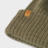 De Lil' Atelier nanson knit muts in de kleur overland trek is de perfecte finishing touch voor de winteroutfit van je kleintje. De muts is gemaakt van een zachte gebreide stof, namelijk 100% wol, en houdt het hoofdje lekker warm tijdens de koude dagen. VanZus
