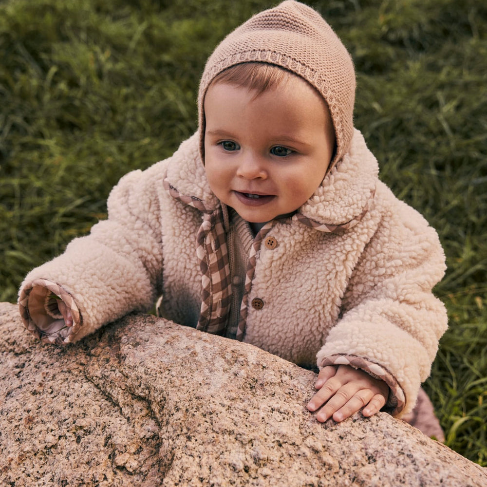 Hoe schattig is de dit noalin baby jasje in de kleur sandshell van het Nederlandse merk Lil Atelier? Dit lieve jasje is de ideale jas voor de wintermaanden! Deze jas is een echte blikvanger en ook nog eens heel warm! VanZus