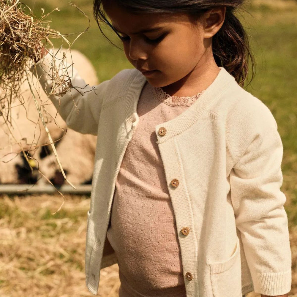 Kleed je kind in comfort met het Lil' Atelier nord knit vestje in turtledove melange. Gemaakt van 50% biologisch katoen en 50% RWS-wol, met knoopsluiting en voorzakken. Perfect voor herfst en winter! VanZus