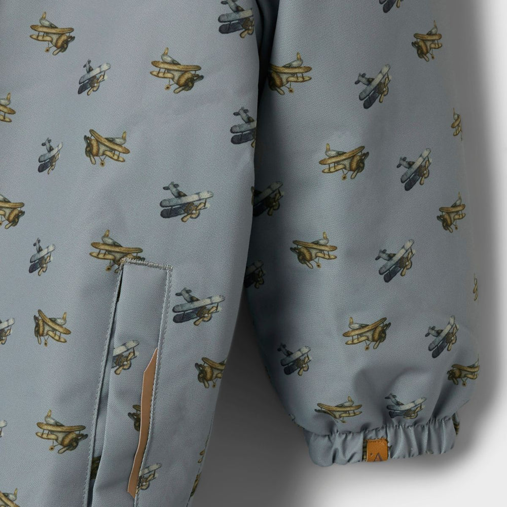 Je kleintje is lekker warm en stijlvol met het snow10 skipak in de prachtige kleur ultimate grey airplanes van het merk Lil' Atelier. Dit functionele en duurzame skipak is waterafstotend en winddicht, ideaal voor koude winterdagen. VanZus