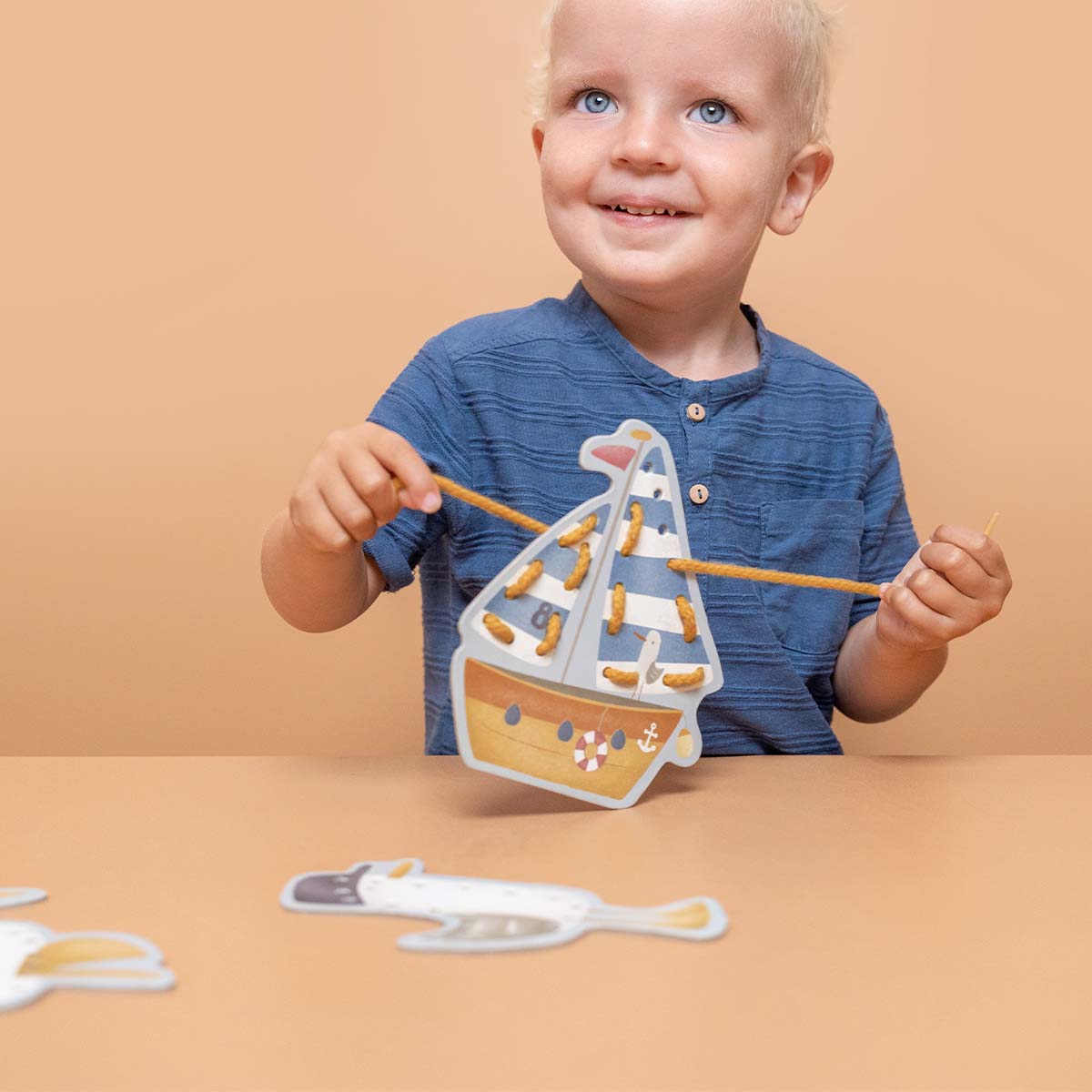 Kaarten rijgen is een ontzettend leuke activiteit voor jouw kleintje! Haal de veter door de kleine gaatjes om wat details toe te voegen aan het grootzeil van de zeilboot, of aan het benedendek van de vissersboot.