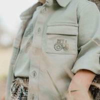 Wat een stoer overshirt in de kleur green van Little Dutch! Voor de kleine binken en avonturiers! Het overhemd heeft een klassieke kraag en een hout-look knoopsluiting. Twee borstzakjes, waarvan één versierd met een klein borduursel van een tractor maken de stoere look compleet. VanZus 