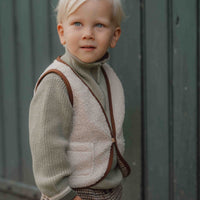 Met het gilet van Little Dutch in de kleur sand voeg je een vleugje stijl toe aan de outfit van je kind. Het gilet is omkeerbaar en kan op twee manieren gedragen worden: de kant van de teddystof of de kant met ruitjesprint. VanZus