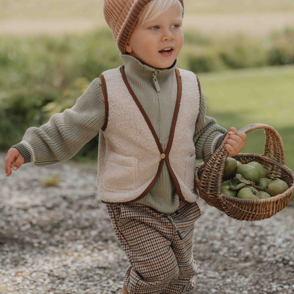 Met het gilet van Little Dutch in de kleur sand voeg je een vleugje stijl toe aan de outfit van je kind. Het gilet is omkeerbaar en kan op twee manieren gedragen worden: de kant van de teddystof of de kant met ruitjesprint. VanZus