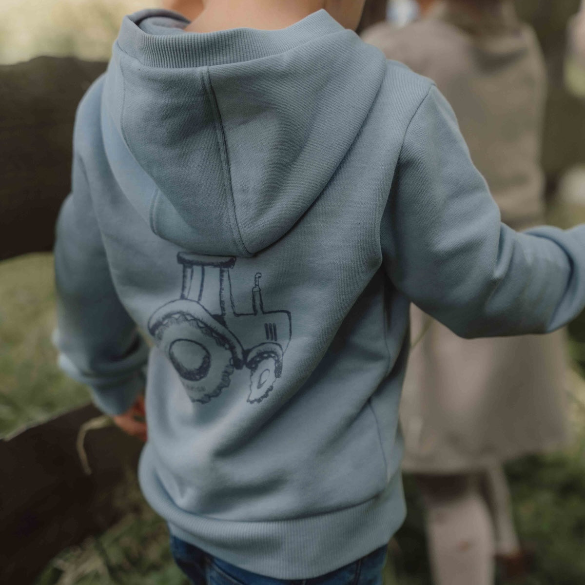 Deze sweater in ice blue van Little Dutch is een heerlijk shirt voor je kleintje om te dragen op de frissere dagen. De capuchontrui heeft een mooie ijsblauwe kleur en op de achterzijde de print van een tractor.  De hoodie is gemaakt van biologisch katoen met een extra zachte binnenkant. VanZus