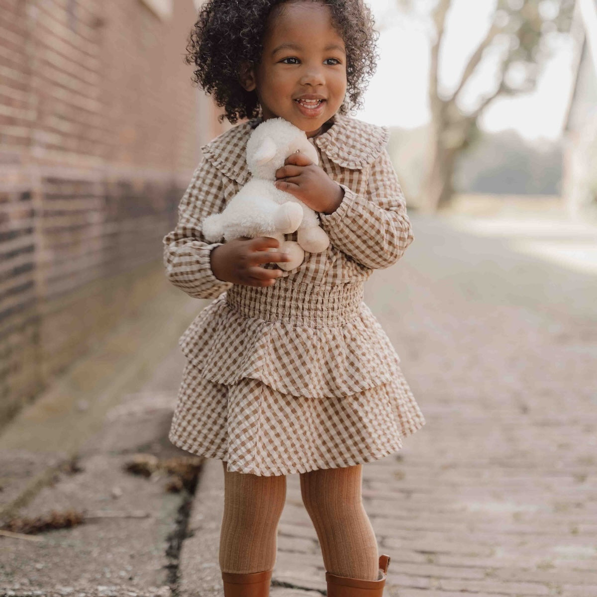 Hoe je de blouse brown check van Little Dutch ook combineert: je meisje zal er geweldig uitzien! De geruite blouse met lange mouwen heeft een bruin-wit patroon en een mooie opvallende kraag met ruches. Zo ziet de blouse er meteen heel bijzonder en meisjesachtig uit. De stof met textuur is van biologisch katoen. VanZus