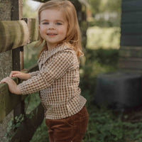 Hoe je de blouse brown check van Little Dutch ook combineert: je meisje zal er geweldig uitzien! De geruite blouse met lange mouwen heeft een bruin-wit patroon en een mooie opvallende kraag met ruches. Zo ziet de blouse er meteen heel bijzonder en meisjesachtig uit. De stof met textuur is van biologisch katoen. VanZus