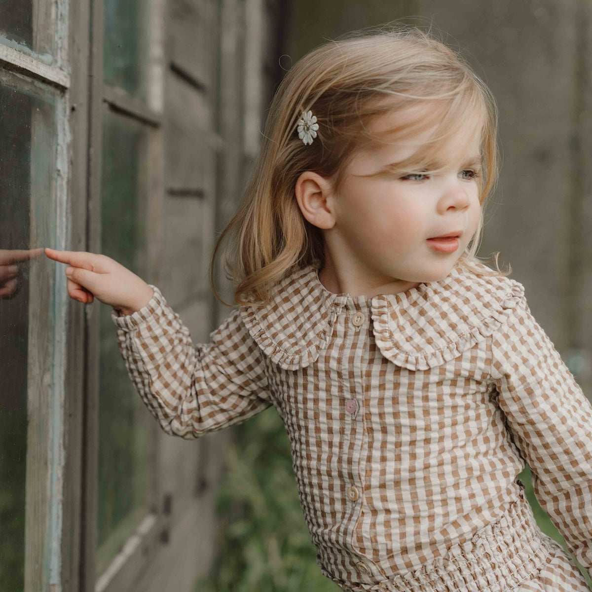 Hoe je de blouse brown check van Little Dutch ook combineert: je meisje zal er geweldig uitzien! De geruite blouse met lange mouwen heeft een bruin-wit patroon en een mooie opvallende kraag met ruches. Zo ziet de blouse er meteen heel bijzonder en meisjesachtig uit. De stof met textuur is van biologisch katoen. VanZus