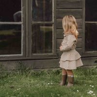 Hoe je de blouse brown check van Little Dutch ook combineert: je meisje zal er geweldig uitzien! De geruite blouse met lange mouwen heeft een bruin-wit patroon en een mooie opvallende kraag met ruches. Zo ziet de blouse er meteen heel bijzonder en meisjesachtig uit. De stof met textuur is van biologisch katoen. VanZus