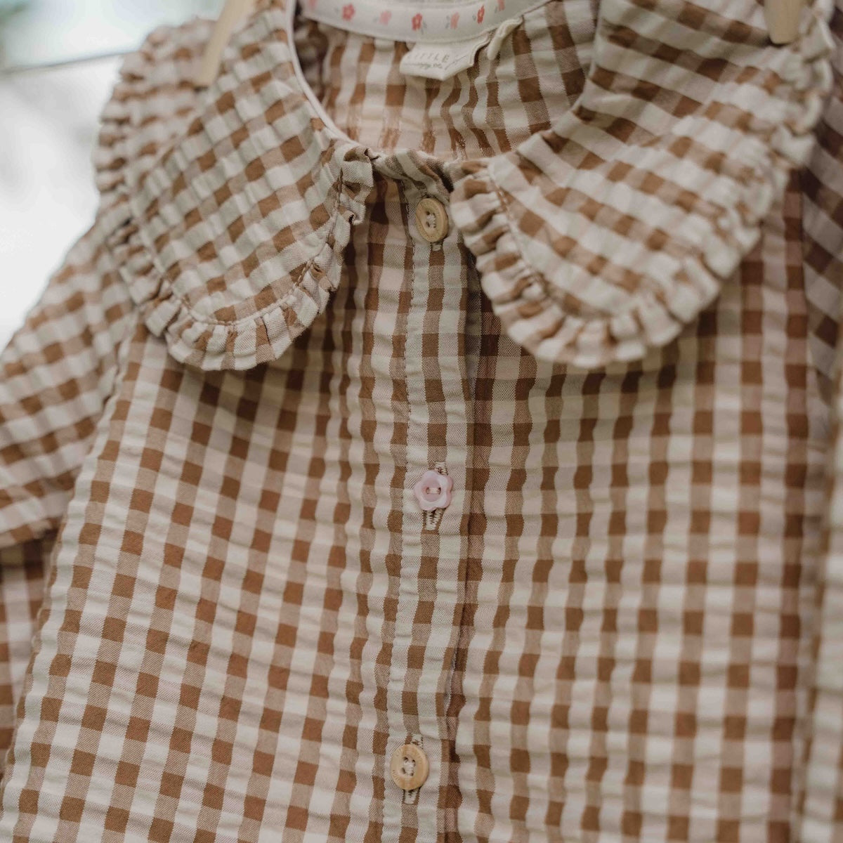 Hoe je de blouse brown check van Little Dutch ook combineert: je meisje zal er geweldig uitzien! De geruite blouse met lange mouwen heeft een bruin-wit patroon en een mooie opvallende kraag met ruches. Zo ziet de blouse er meteen heel bijzonder en meisjesachtig uit. De stof met textuur is van biologisch katoen. VanZus