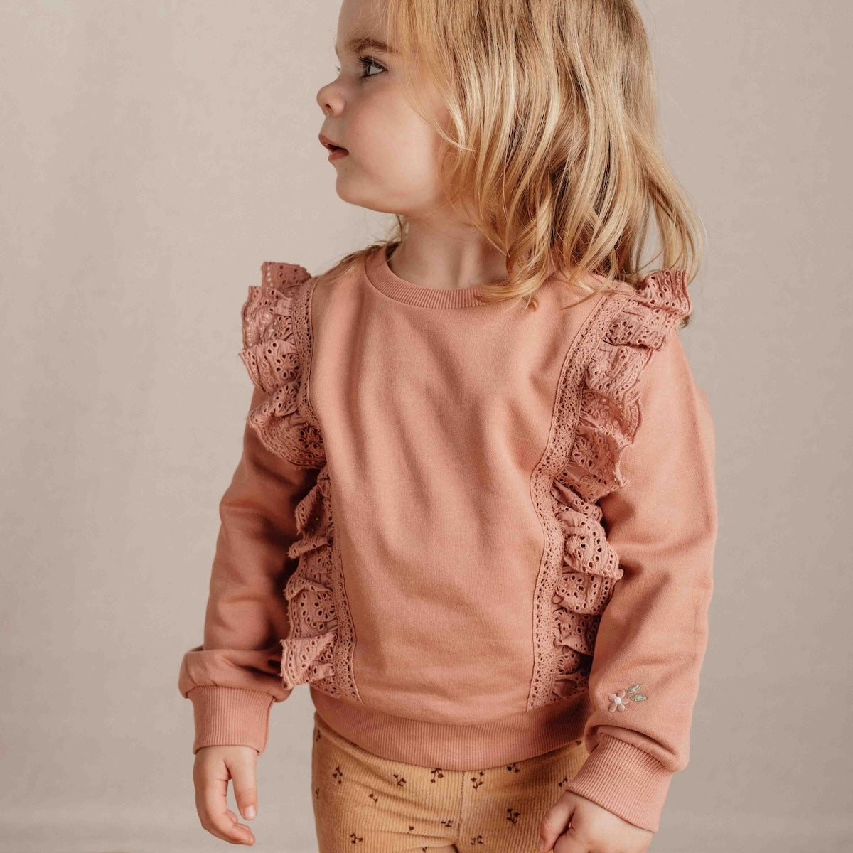 Deze schattige sweater in warm pink van Little Dutch is een heerlijk zacht voor je kleine meisje! Gemaakt van biologisch katoen met extra zachtheid aan de binnenkant. De ruches met geborduurde bloemetjes langs beide zijden van de trui en een bloemborduursel op één van de mouwen voegt een leuk detail toe.  VanZus