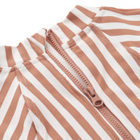 Hip én handig: het baby uv-badpak maxime stripe tuscany rose/creme de la creme. Het badpak beschermt jouw kind tegen de schadelijke uv-straling door de lange mouwen, hoge kraag en UPF40+. Met drukknopen en rits. VanZus