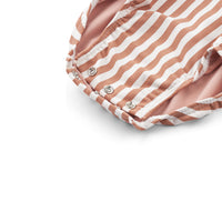 Hip én handig: het baby uv-badpak maxime stripe tuscany rose/creme de la creme. Het badpak beschermt jouw kind tegen de schadelijke uv-straling door de lange mouwen, hoge kraag en UPF40+. Met drukknopen en rits. VanZus