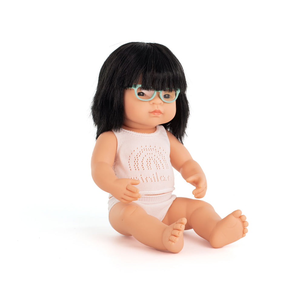 Wat een schatje: de babypop Aziatisch meisje met bril van Miniland. Een zacht lijfje met beweegbare armen en benen. Ruikt naar een vleugje vanille. Kleed de pop zelf aan. In verschillende soorten. 38 cm. VanZus