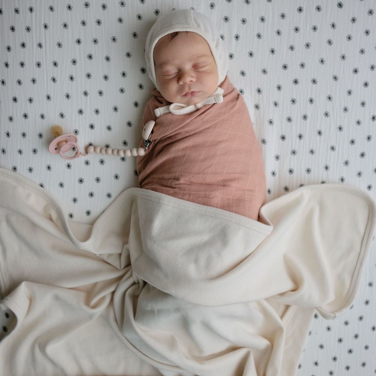 De stijlvolle Mushie rib deken in ivory, gemaakt van 100% katoen, biedt zachtheid en ademend comfort. Afmeting: 80x100 cm,  ideaal voor wieg, kinderwagen of als wikkeldeken. VanZus