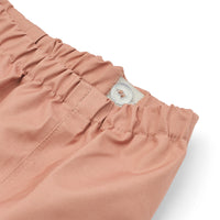 Hijs je kindje in deze coole pedia broek in de kleur tuscany rose en de regenpret kan beginnen! Deze broek van het merk Liewood is ideaal voor op regenachtige dagen! Deze broek is water- en winddicht, heeft verstelbaar elastiek bij de taille zodat hij altijd goed zit en heeft een mooie oranje kleur. VanZus