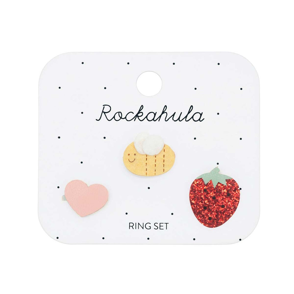 Een vrolijke set ringen uit de collectie strawberry fair van het Engelse merk Rockahula. 3 verschillende verstelbare ringen met hart, bij en aardbei versiering. Ook leuk met bijpassende ketting. VanZus